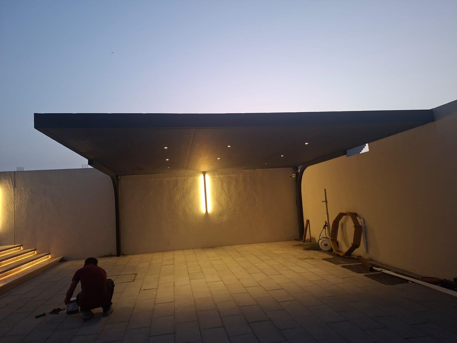 Cantilever carport with wall LED strip and recessed lights at dusk