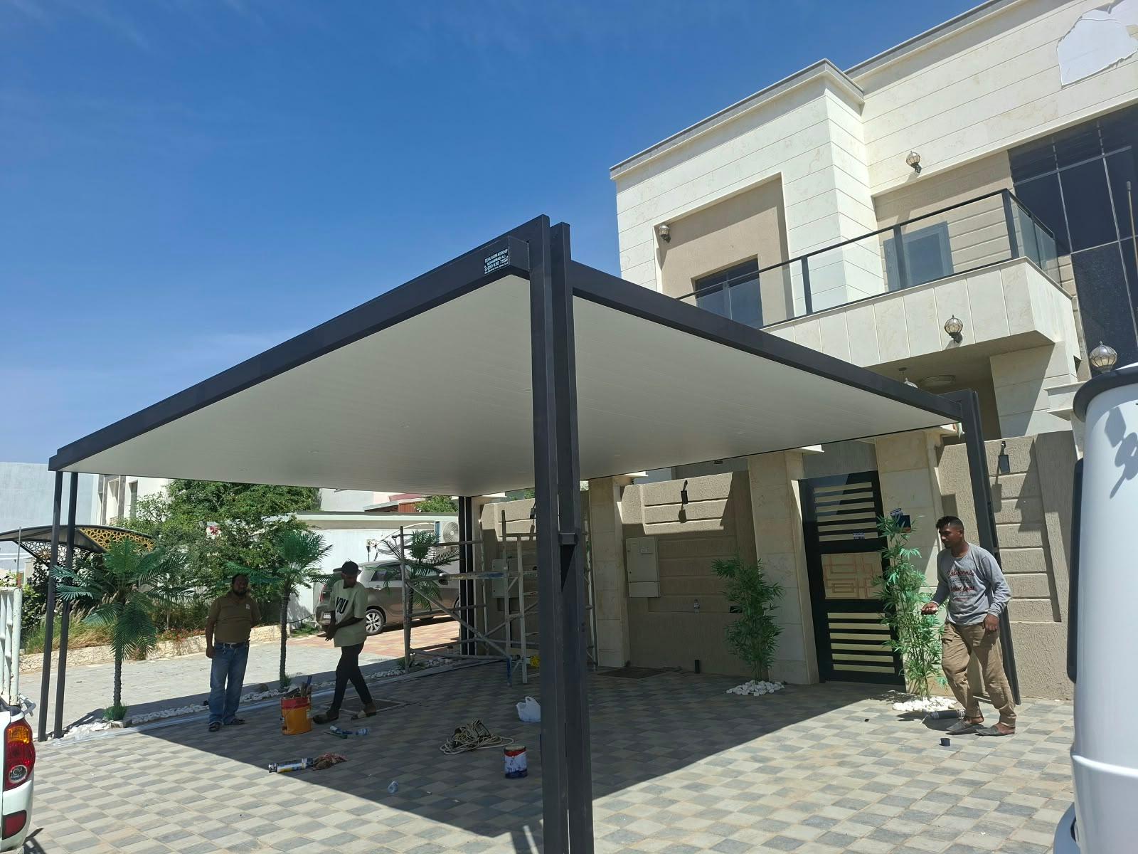 Black-frame parking canopy with white ceiling installed at a villa driveway