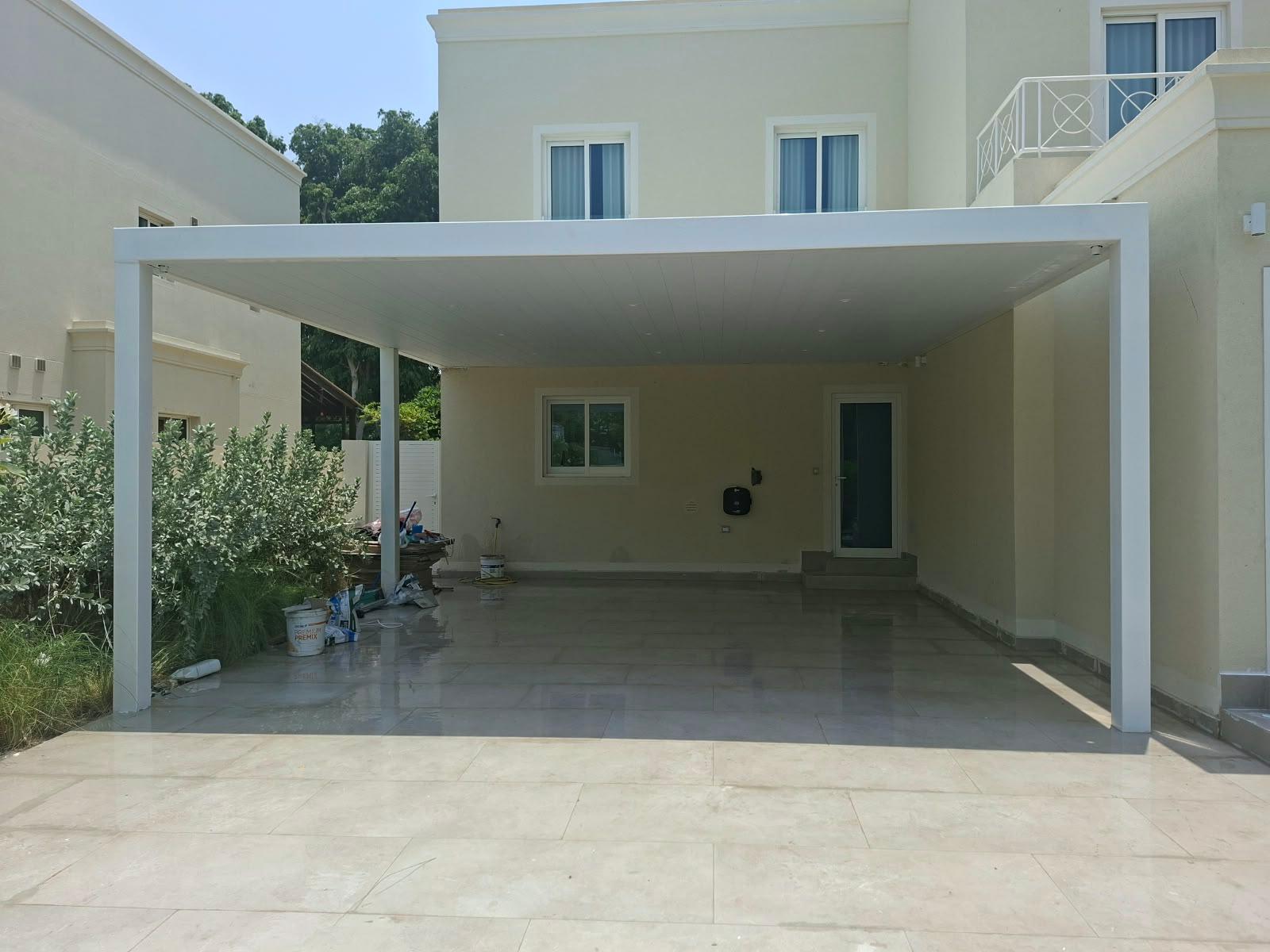 White metal parking pergola attached to a villa elevation
