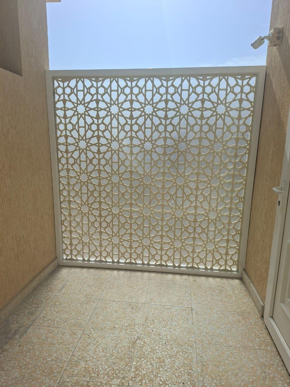 Precision-cut geometric mashrabiya privacy screen on a villa balcony