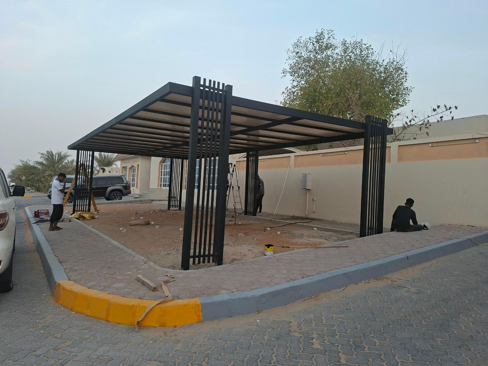 Installation crew working on a black steel pavilion frame