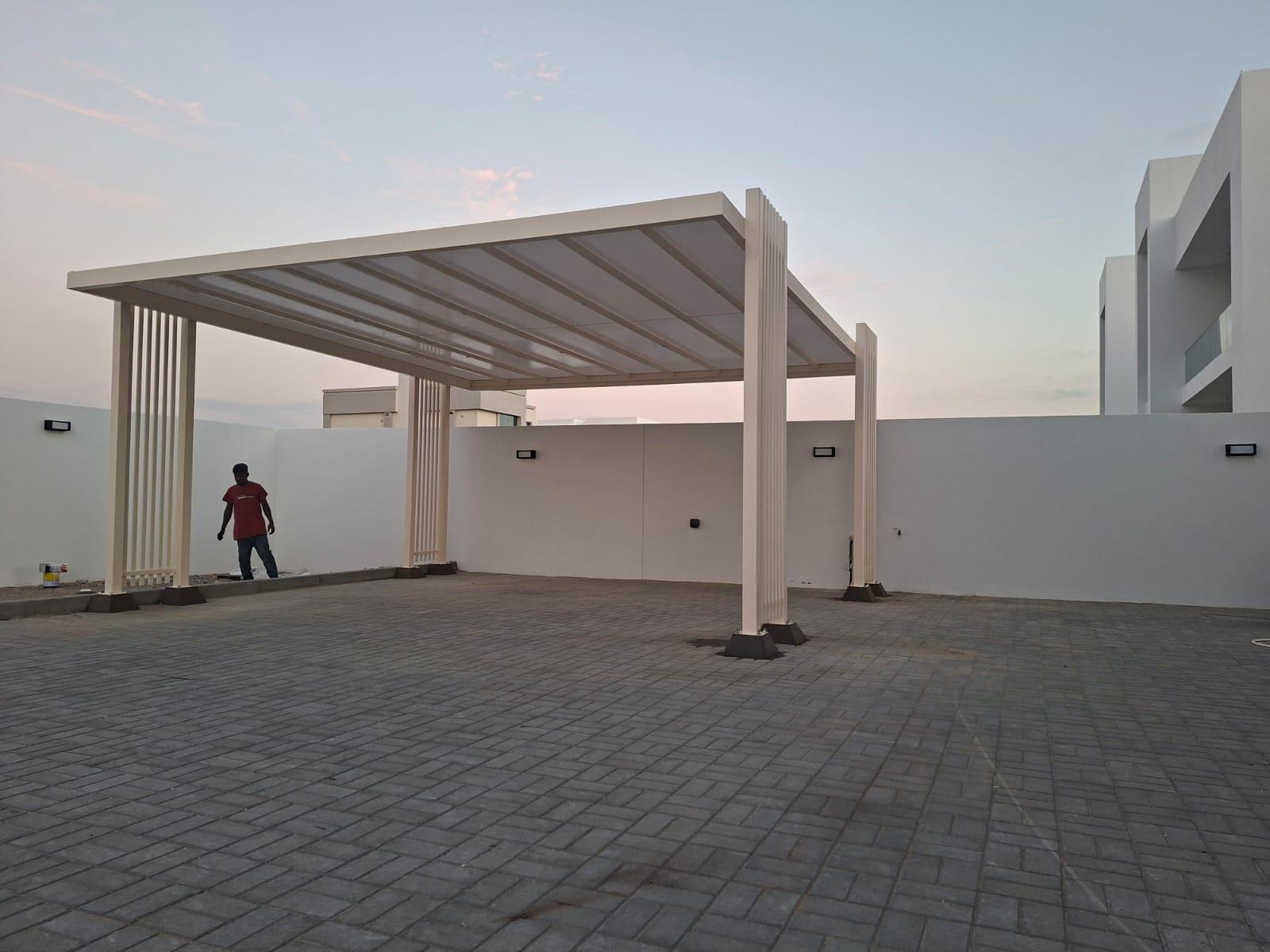 Cream slatted steel pavilion with clustered pillars in a paved courtyard